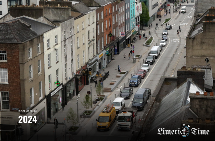 Busy Limerick street with dedicated bus lanes and public transport in use during the day.